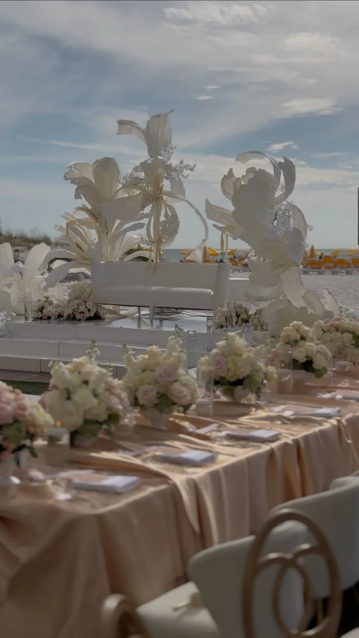 Beachfront lounge with sculptural white florals and a white stage